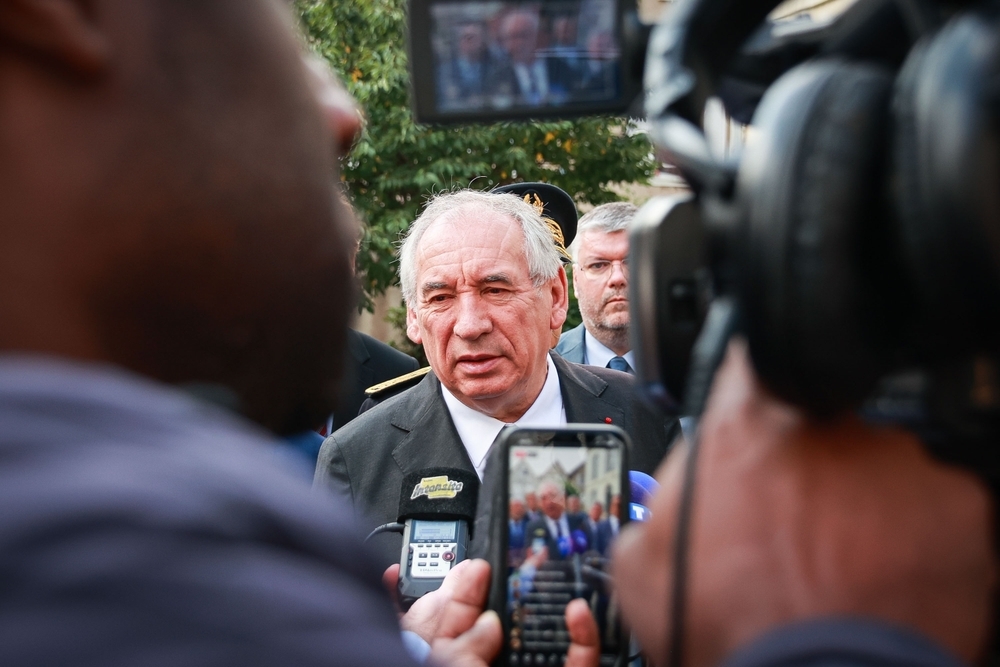 François Bayrou entouré de journalistes en 2025, mis en cause pour avoir ignoré des alertes sur des violences scolaires à Pélussin en 1996